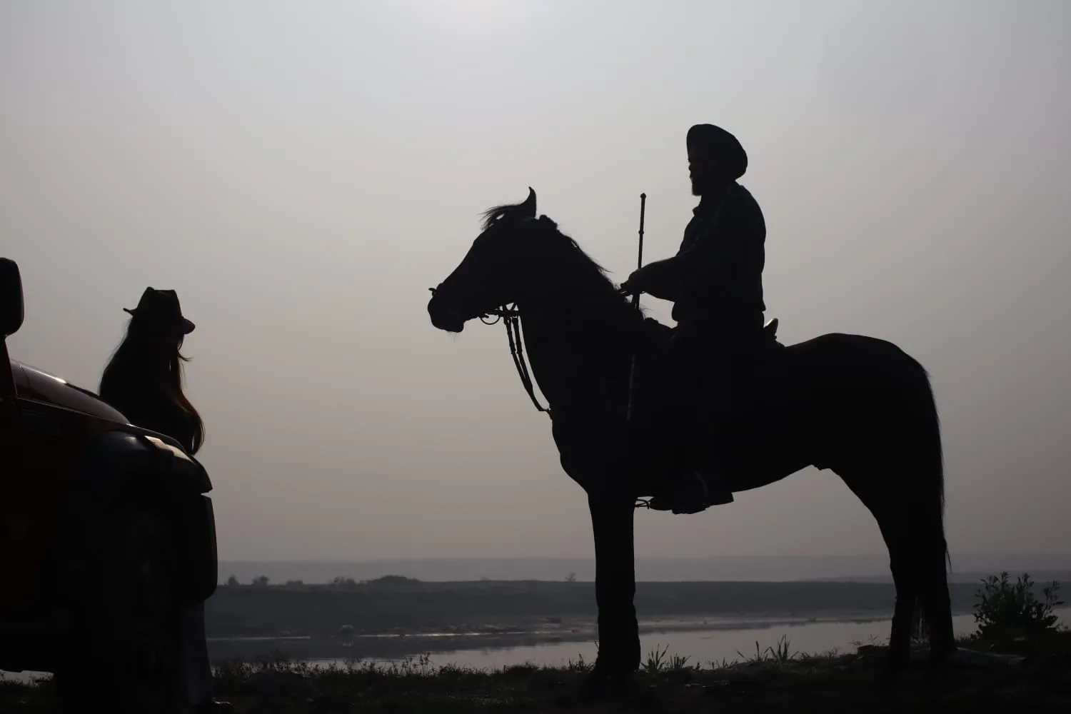 Rider on a Marwari horse at sunset on the FHRC trail beside a jeep, Faridabad.