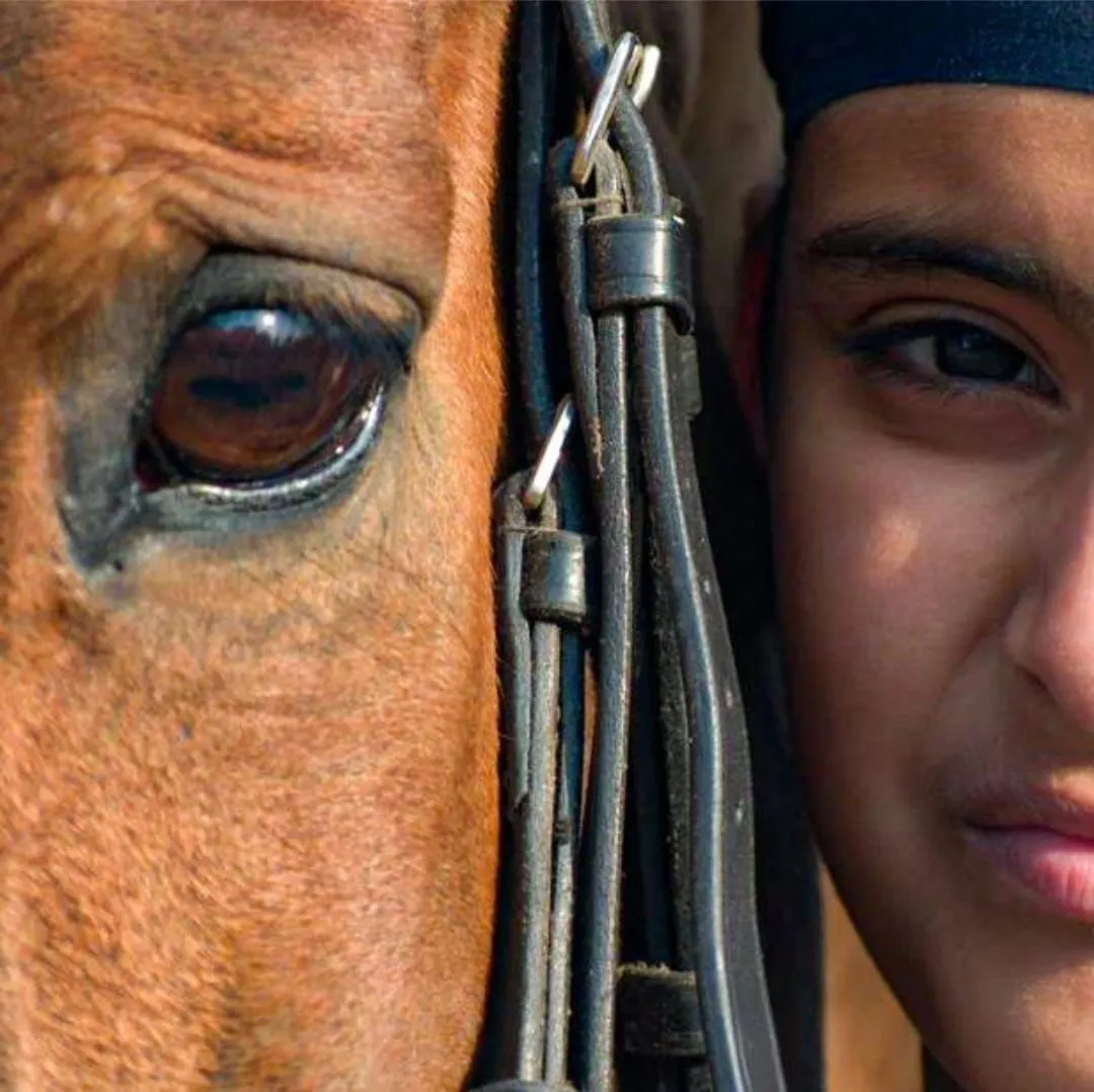 A young rider bonding eye-to-eye with a horse at the FHRC riding community, Faridabad.